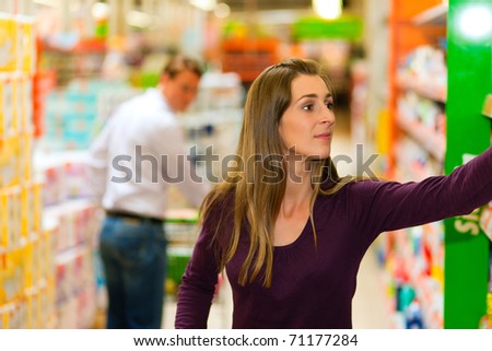 Man in the supermarket looking after a girl he just met shopping there, he is ready to flirt a bit