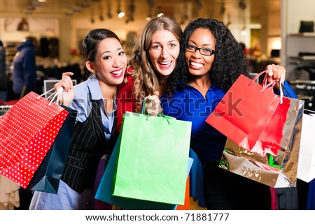 Group of three women - white, black and Asian Ã¢Â?Â? shopping downtown in a mall