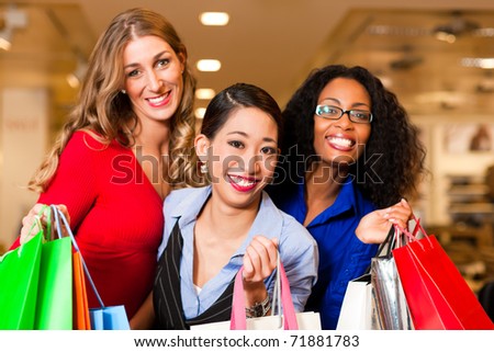 Group of three women - white, black and Asian Ã¢Â?Â? shopping downtown in a mall