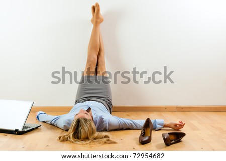 Businesswoman is lying on the floor at home relaxing