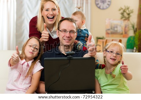 Young Family In Front Of Computer With Camera Having A Video Chat