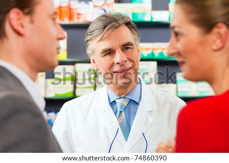 Pharmacist is consulting customers in his pharmacy - a man and a woman