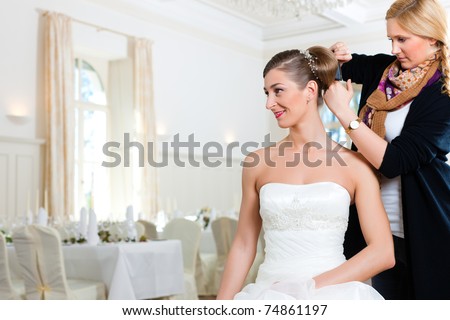 Stylist pinning up a bride\'s hairstyle before the wedding