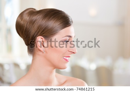 Smiling bride with swept-back hair before the wedding
