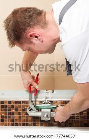 Plumber installing a mixer tap in a bathroom