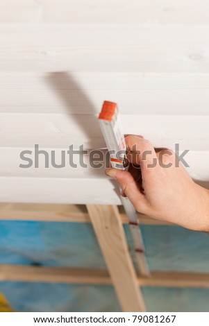Man doing dry walling, working with a folding rule