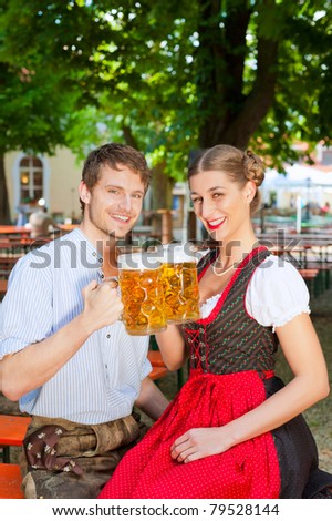 Couple with beer stein and traditional clothes in a beer garden