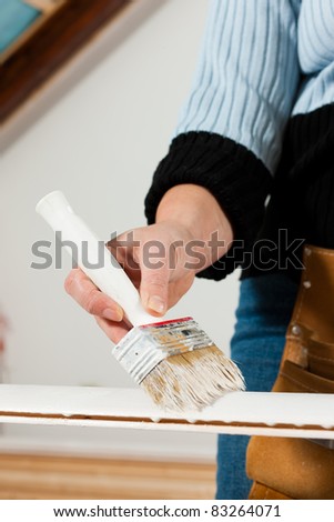 woman - only hands to be seen -  is painting in her house; presumably she is renovating