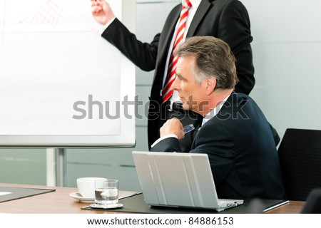 Business - Senior Manager or boss in meeting while a colleague is presenting a new strategy