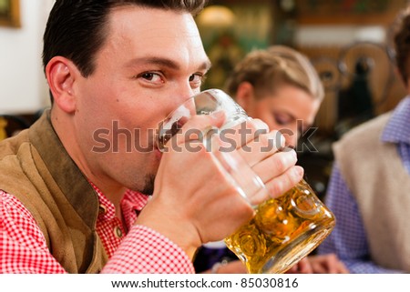 Inn or pub in Bavaria - man in traditional Tracht drinking beer