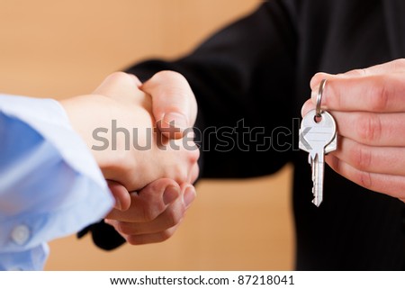 Two businessperson shaking hands; only hands to be seen and a key is be given