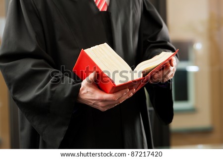 German Lawyer with civil law code in a court room, close-up, only torso to be seen