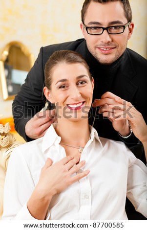 Man giving his wife a necklace as a gift