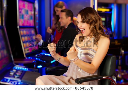 Happy couple in Casino on a slot machine winning Stock Photo - 9860712