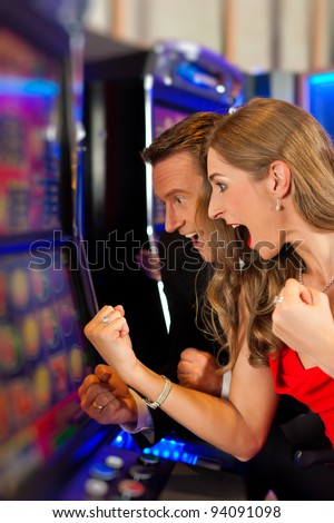 stock-photo-couple-in-casino-on-a-slot-machine-winning-and-having-fun-94091098.jpg