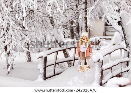 little girl standing on a snow-covered bridge on