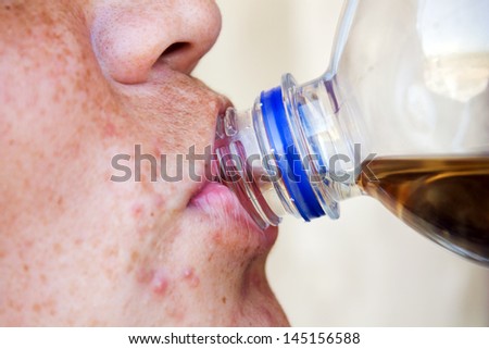 man drinks juice through a throat