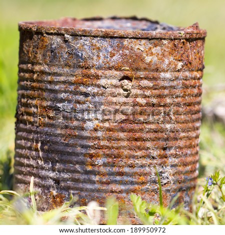 rusty canned bank on green grass