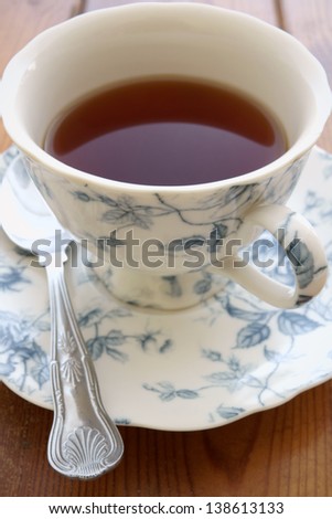 Black tea in an ornate floral china cup and saucer