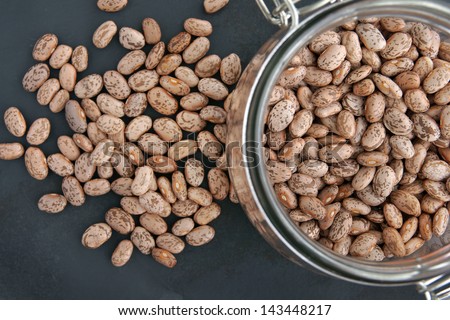 Pinto beans with selective focus on the beans in a storage jar.