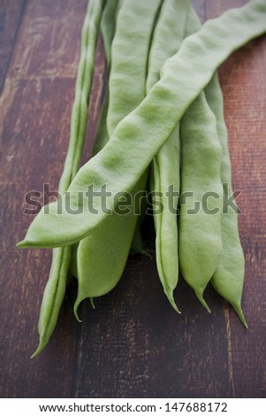 Green Runner Beans on a rustic table surface