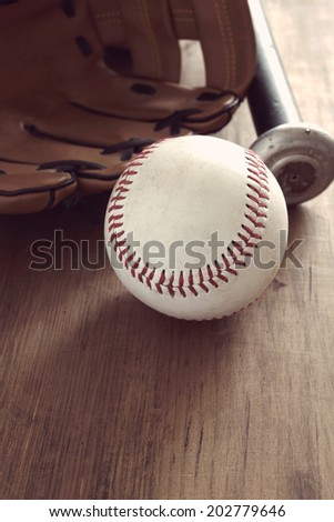 Old baseball with mitt and bat with vintage style filter applied to image