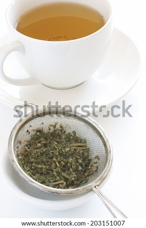 Making herbal or green tea with leaves in a tea sieve