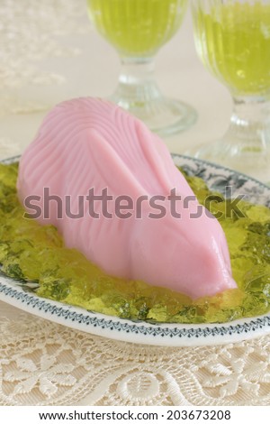 Pink blancmange in the shape of a rabbit on green jelly grass