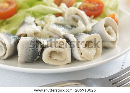 Rollmops or pickled herring fillets served with salad a popular seafood in Northern Europe