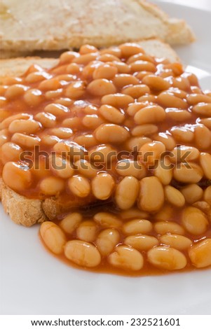 Baked beans in tomato sauce on toast selective focus on front beans
