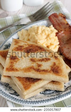 Irish potato farls or potato cakes with bacon and scrambled eggs