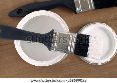 Painting and decorating top down view of a pot of white paint and brush