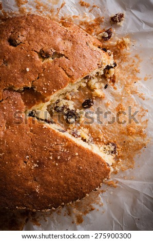 Traditionally home baked farmhouse sultana or dried fruit light sponge cake with a slice removed low key lighting