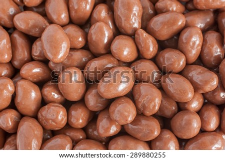 Peanuts covered in a milk chocolate coating top down view