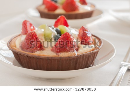 Fruit tarts made filled with creme patissiere strawberries kiwi fruit and blueberries