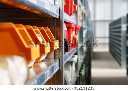Storage bins and racks for storing parts and components in a warehouse shot with shallow focus