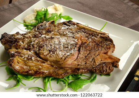 Grilled sirloin beef steak on white plate, BBQ meat
