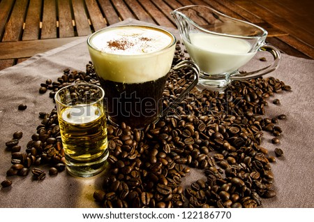 Warm Irish Coffee with coffee beans, whiskey and cream
