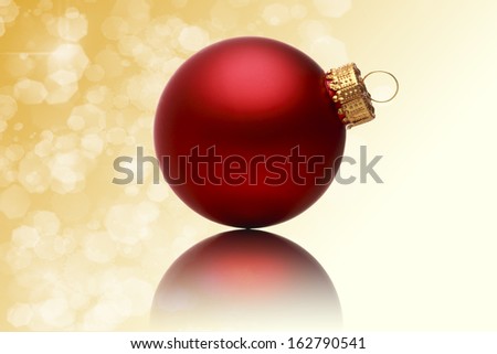 close up of a red christmas ball with blurred yellow background.