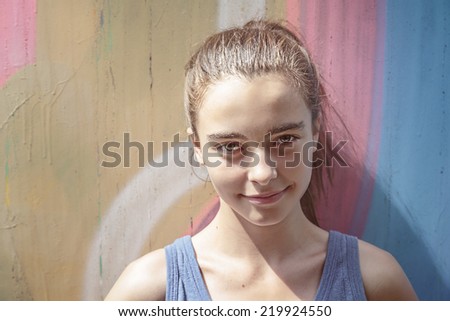 toned image, smiling girl in front of a graffiti