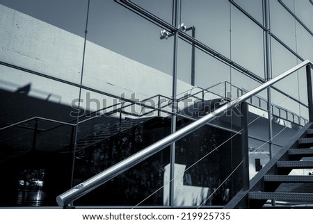 detail of a glass facade with reflection and handrail
