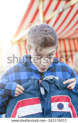 funny teenage boy on a flea market is trying too small dresses