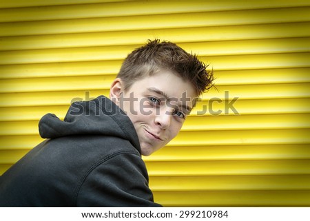 portrait of a male teenager with yellow rolling shutter in background