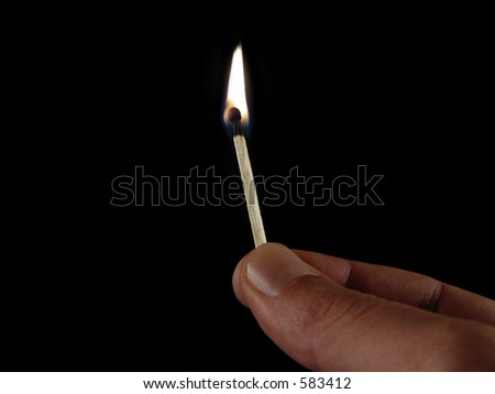 Fingers holding a match infront of black background