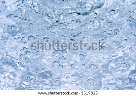 Close-up of bubbled water with soft blue/grey soft background freezed in motion