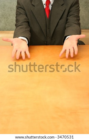 Business-man sitting at the desk, open hands.