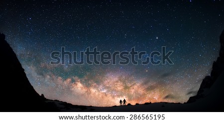 Two people standing together holding hands against the Milky Way galaxy in the mountains. Nepal, Himalayas, Everest region, Gokyo (4,790 m).