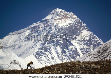 A man is standing in front of the world\'s highest mountain - Mt. Everest. Nepal, Everest region (Sagarmatha National Park), Mt. Everest (8,850 m).