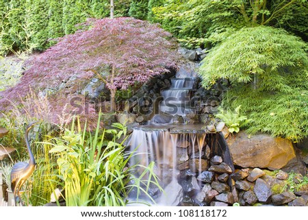 Backyard Waterfall Pond with Japanese Maple Trees and Bronze Crane Statue