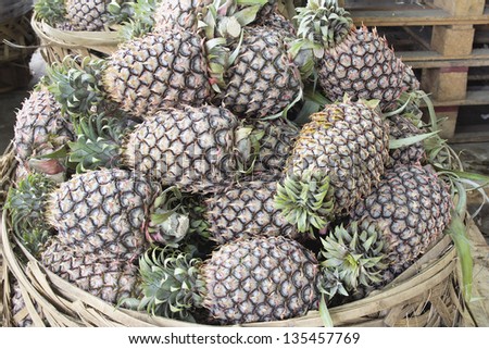 Pineapples Piled up in Basket at Fruits and Vegetables Market in Southeast Asia with Natural Lighting